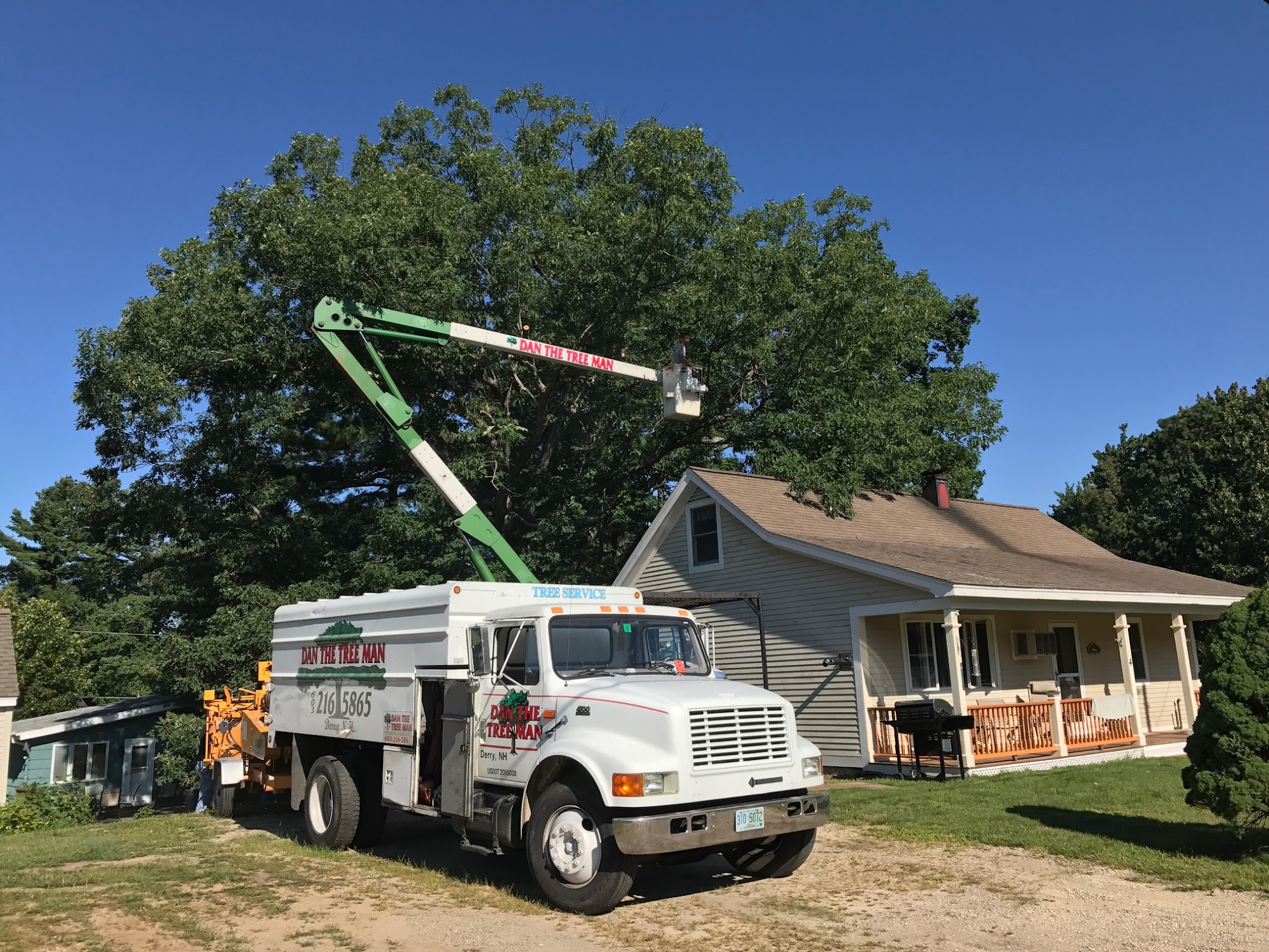 Bucket truck trimming trees at residential home